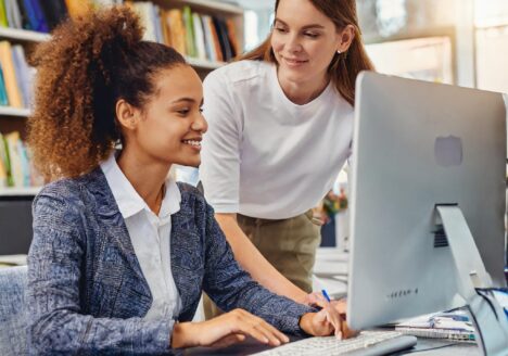 adult learner signing into computer with help from IT